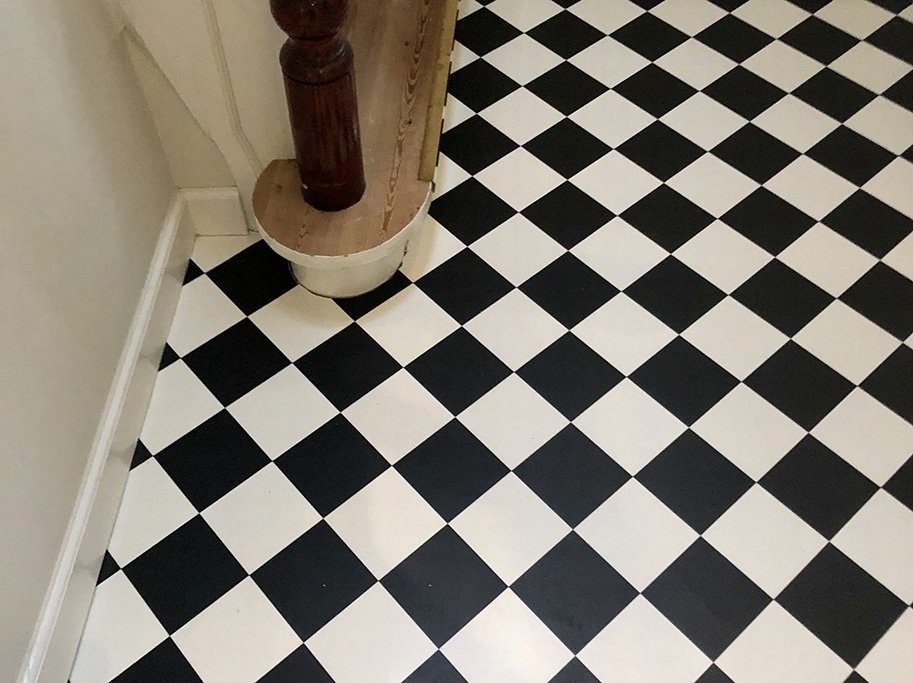 Vinylgulv med sorte og hvide tern der står på højkant